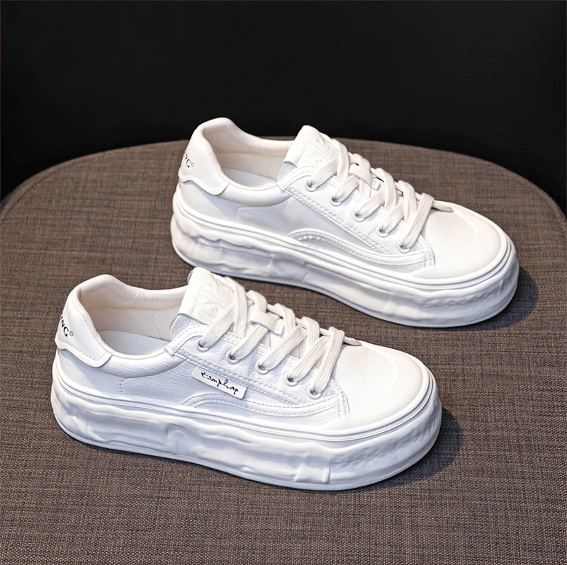 White women's thick sole lace-up sneakers on display.